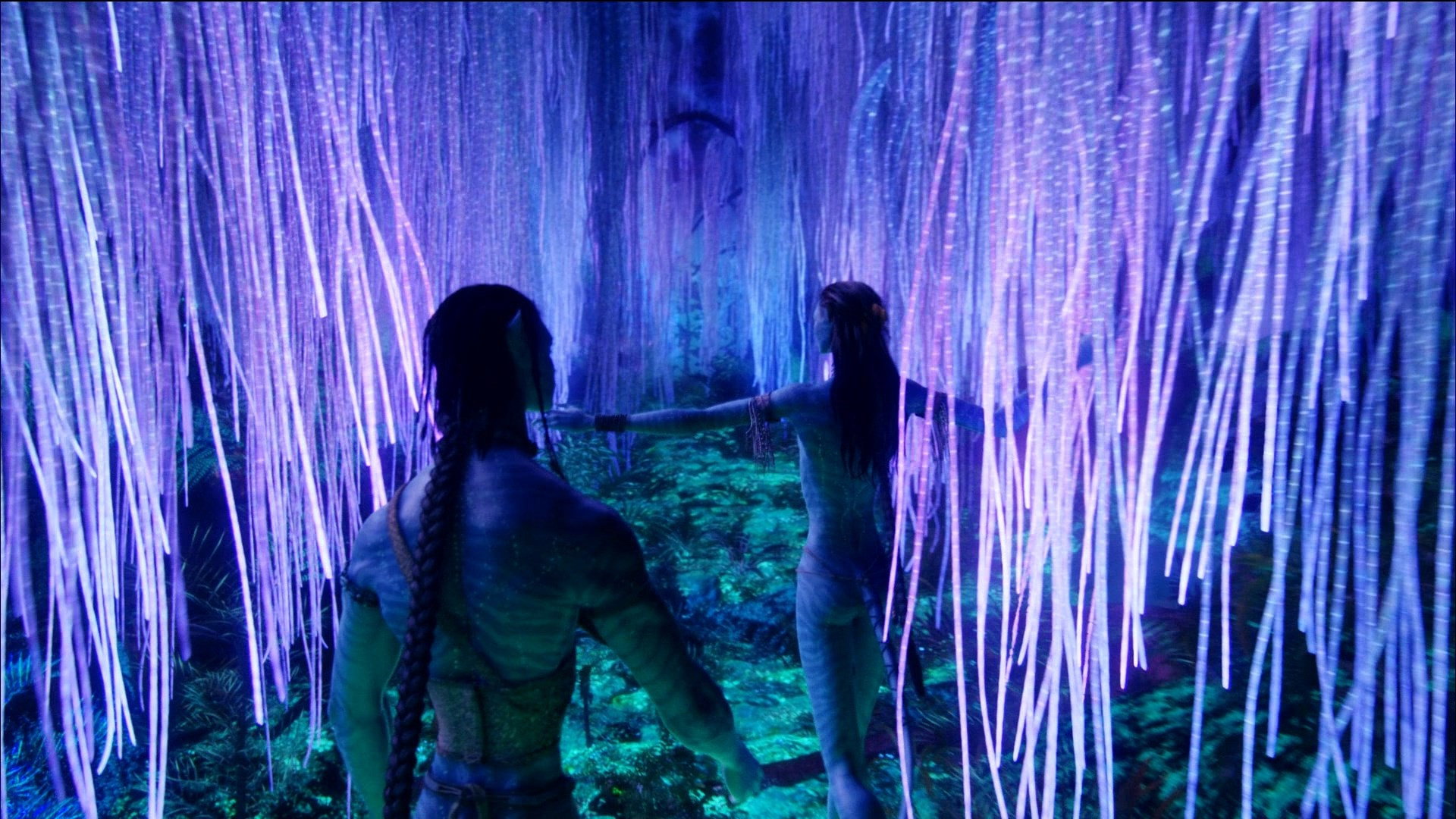 Duas figuras Na'vi de mãos dadas diante de raízes luminosas roxas e violetas da Árvore das Almas