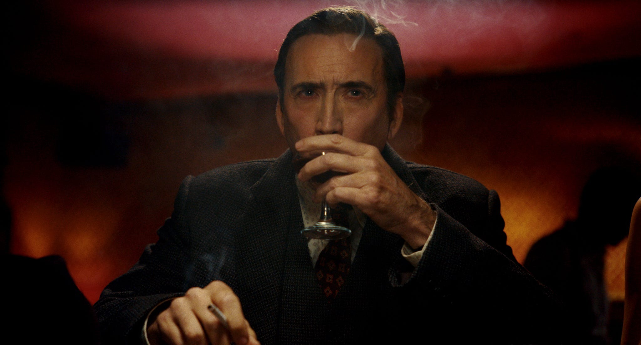 Poster oficial de Spider-Noir em preto e branco, Nicolas Cage de chapéu e sobretudo sob chuva neon