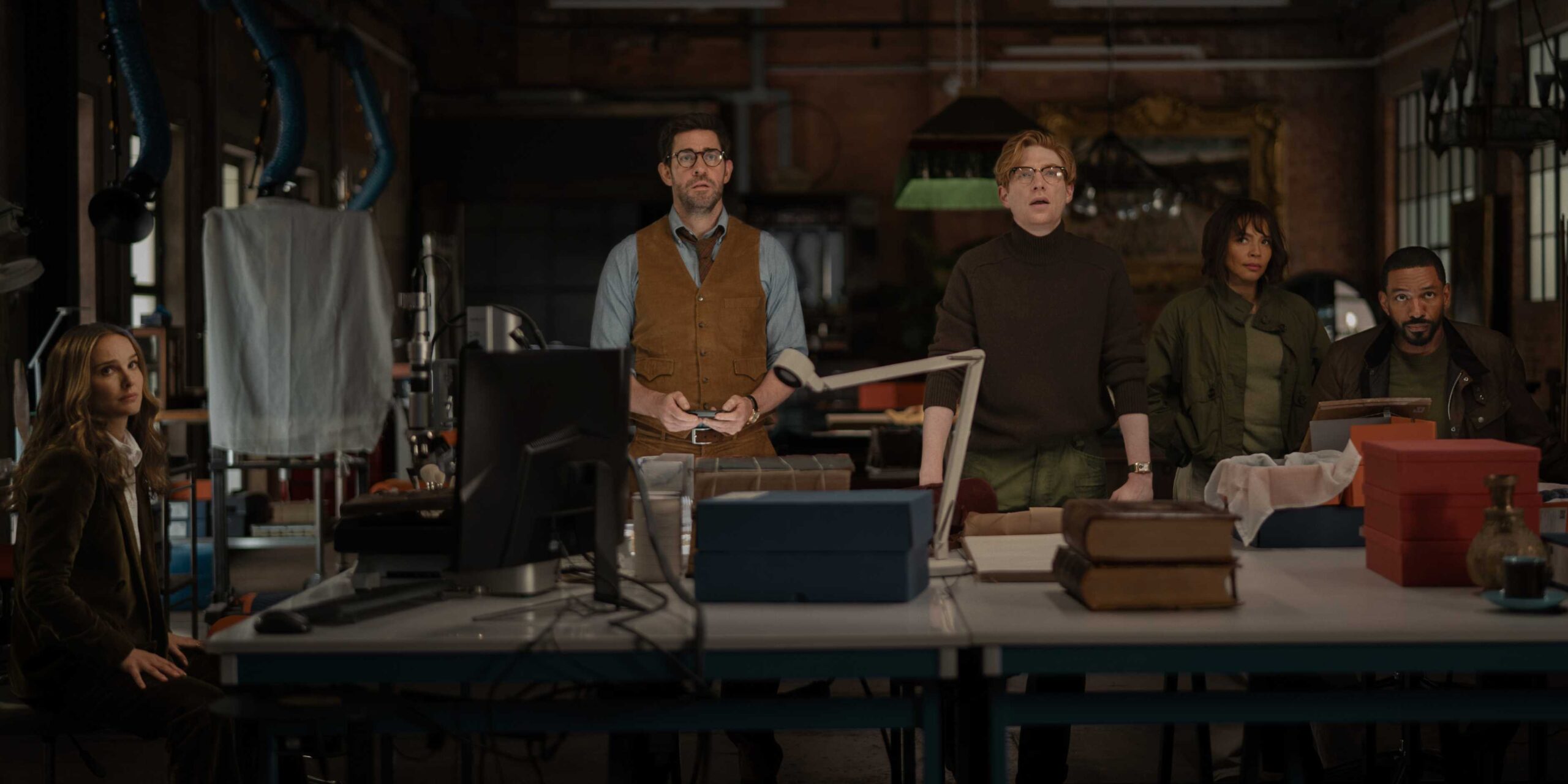 Luke e Charlotte ao redor de uma mesa com toda a equipe olhando para algo em Fountain of Youth