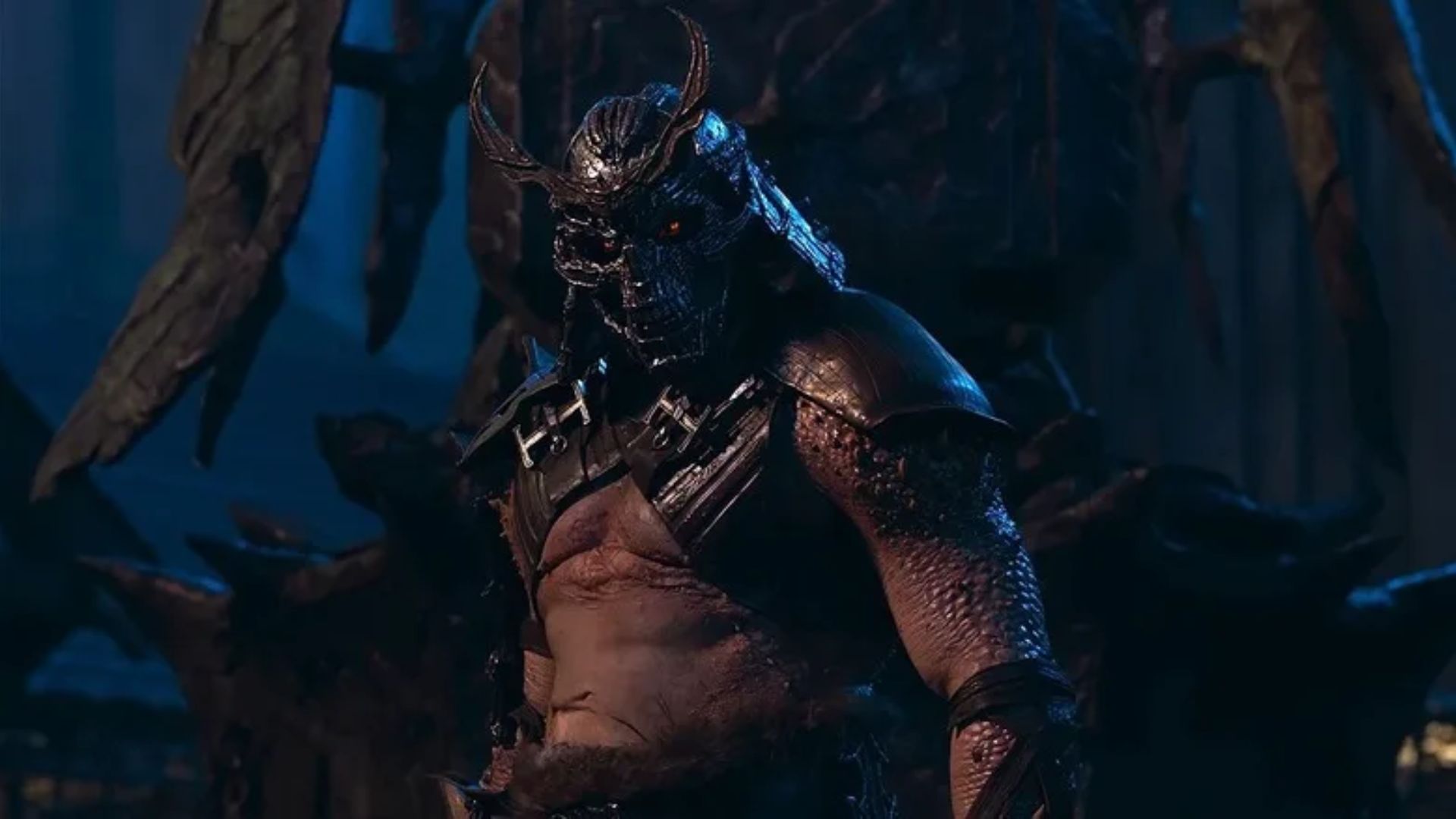 Shao Kahn em Mortal Kombat 2 usando armadura completa em cena de batalha sombria
