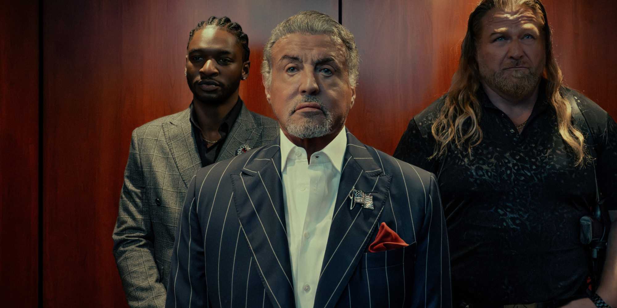 Sylvester Stallone como Dwight Manfredi ladeado por Jay Will como Tyson Mitchell e Mike Walden como Bigfoot em Tulsa King temporada 3