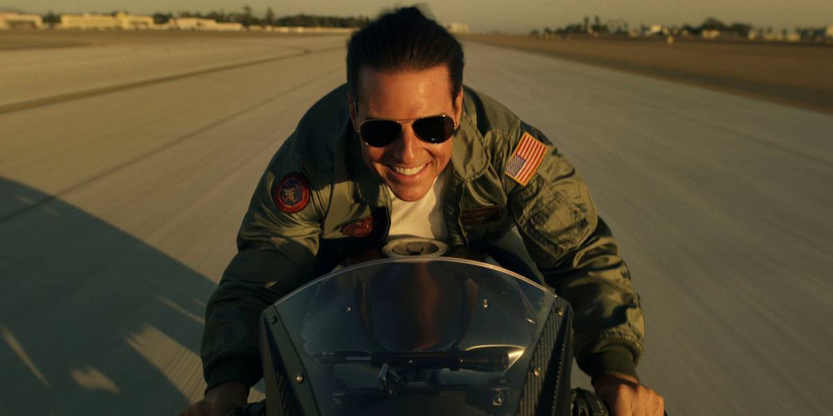Cena de Top Gun: Maverick com Maverick no cockpit durante voo, foco na escala da ação aérea