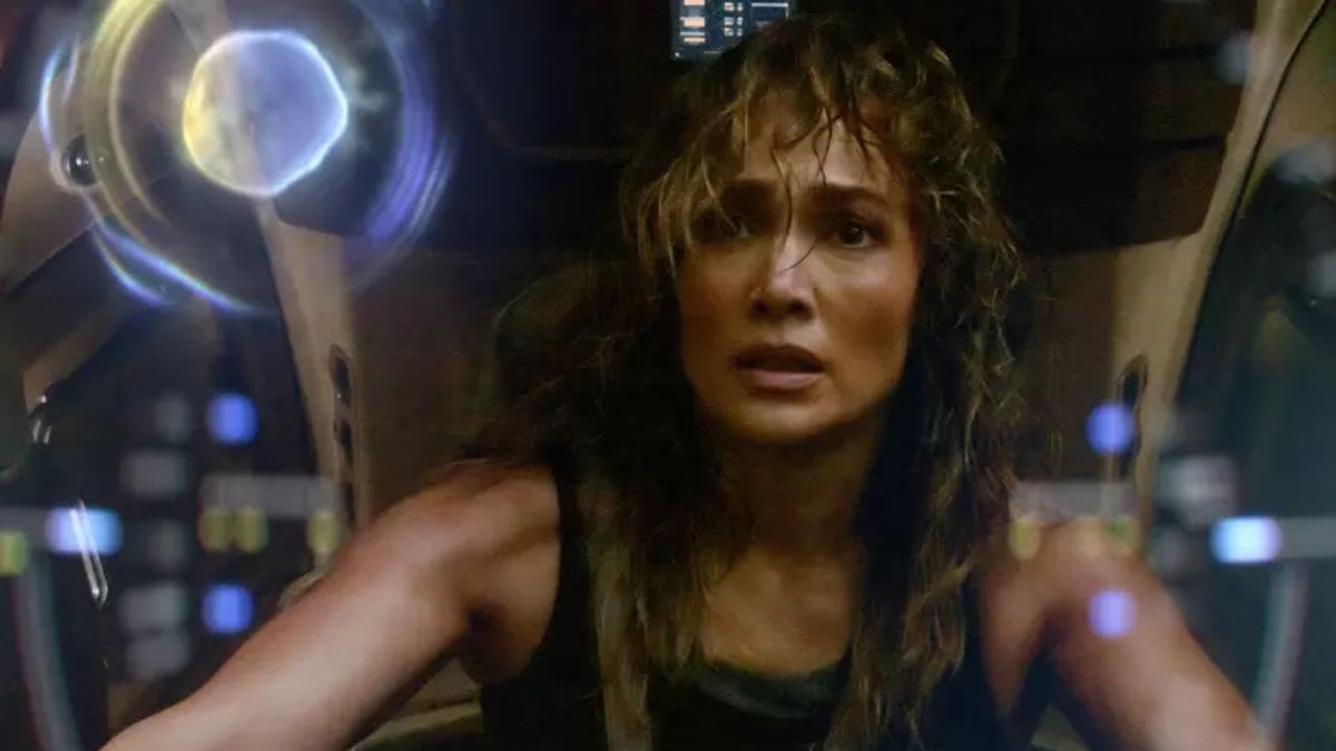 Jennifer Lopez e Brett Goldstein em cena romântica de Paixão de Escritório, foto oficial da Netflix