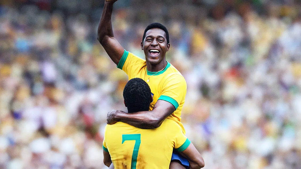 Elenco de Brasil 70: A Saga do Tri recriando a Seleção de 1970 em campo, com uniforme amarelo clássico