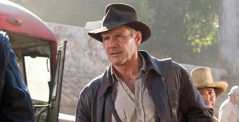 Sam Neill como Alan Grant em Jurassic Park: O Parque dos Dinossauros, olhando assustado para os dinossauros ao lado de Laura Dern