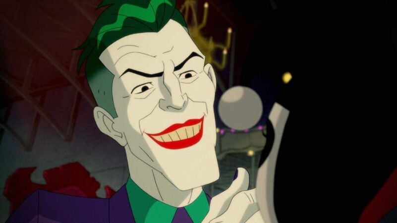 Yasuhiro Aoki em evento de animação, com artes de produção ao fundo relacionadas a Joker: Laugh Riot