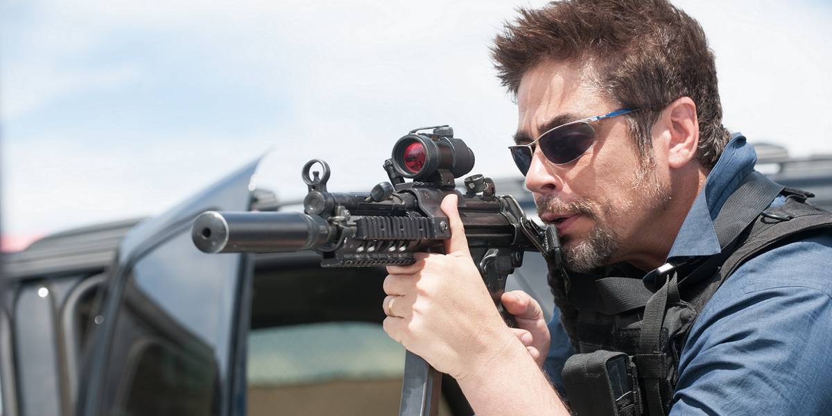 Benicio del Toro apontando uma arma em Sicario.