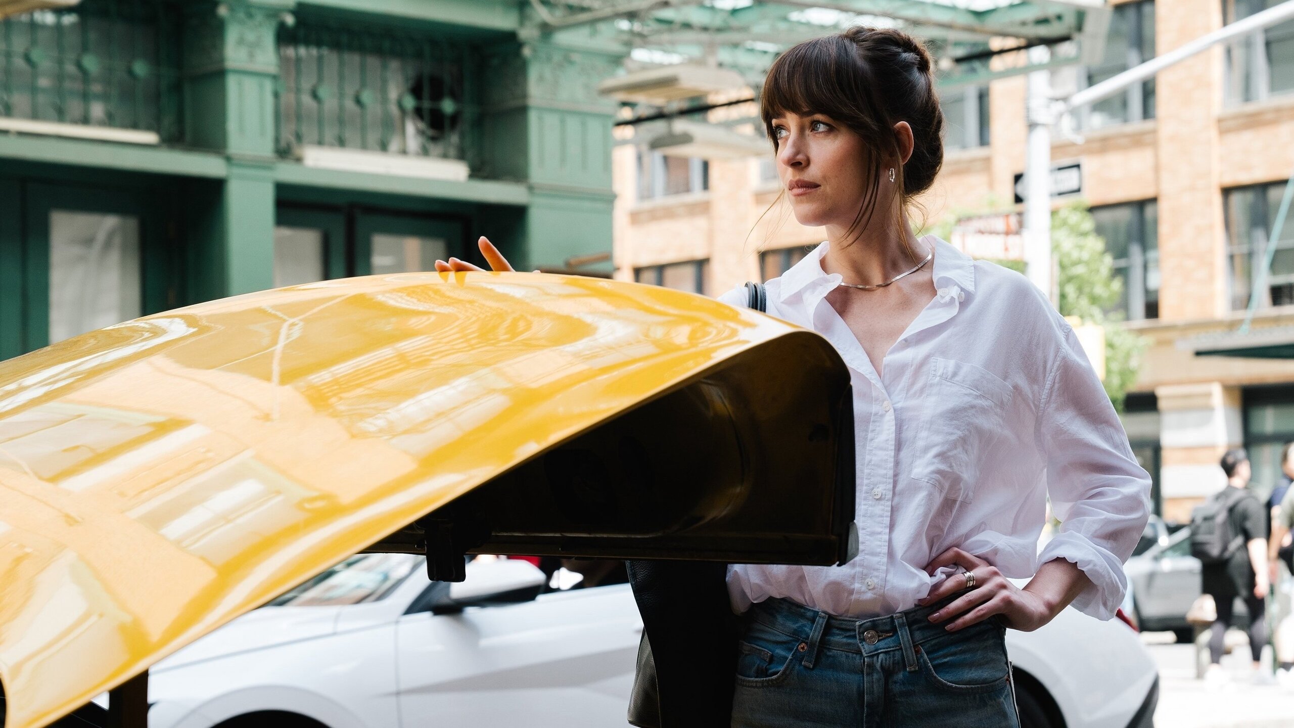 Mulher em frente a táxi amarelo em rua de Nova York com edifícios clássicos ao fundo