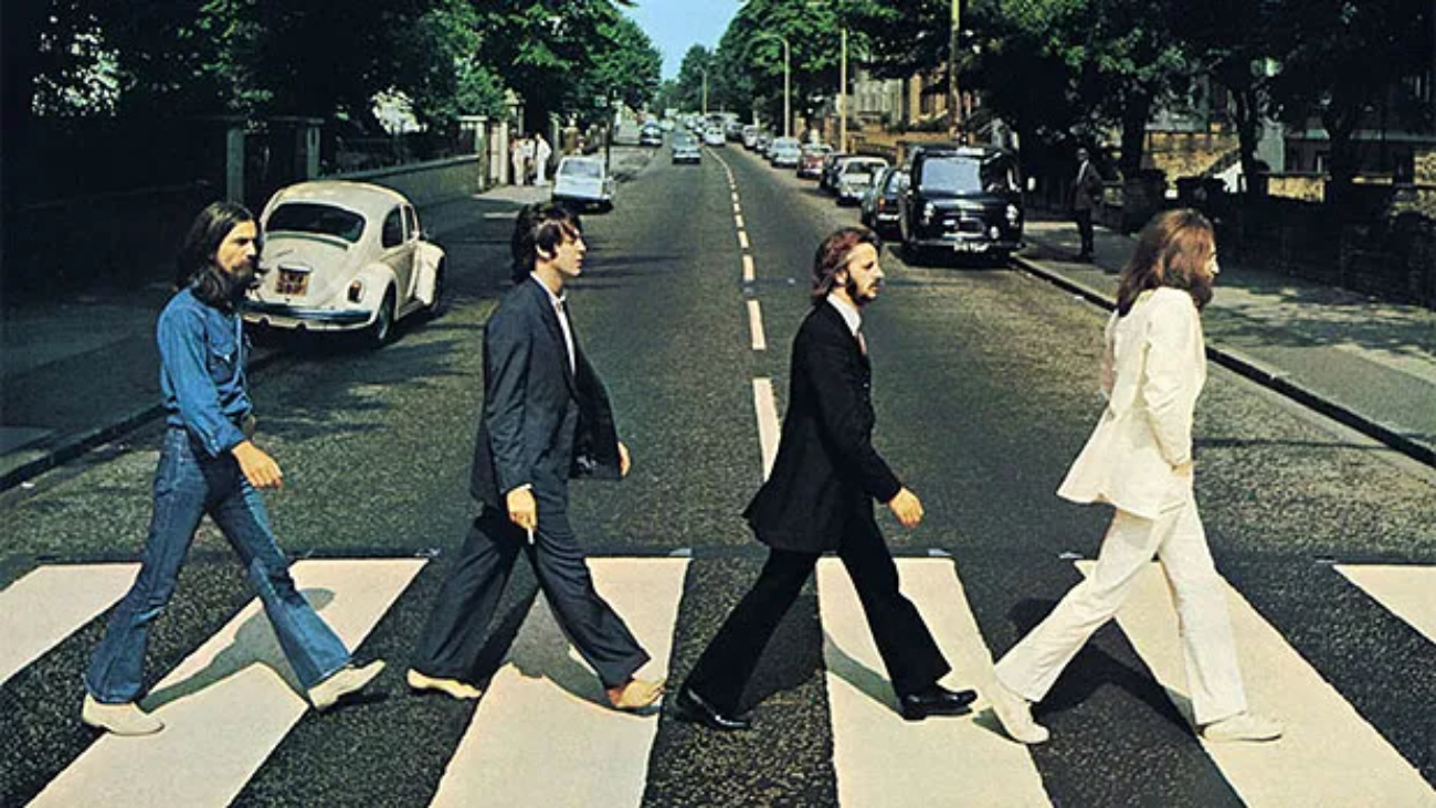 Elenco jovem de Hamburg Days caracterizado como os Beatles no início da carreira, cenário de clube em Hamburgo