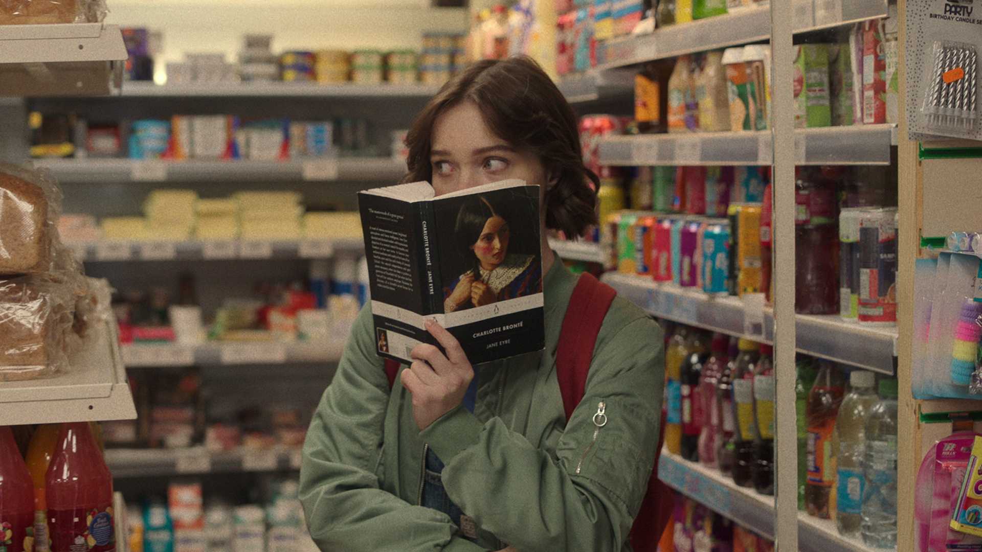 Emma Myers olha um livro como Pip Fitz-Amobi em A Good Girl's Guide to Murder