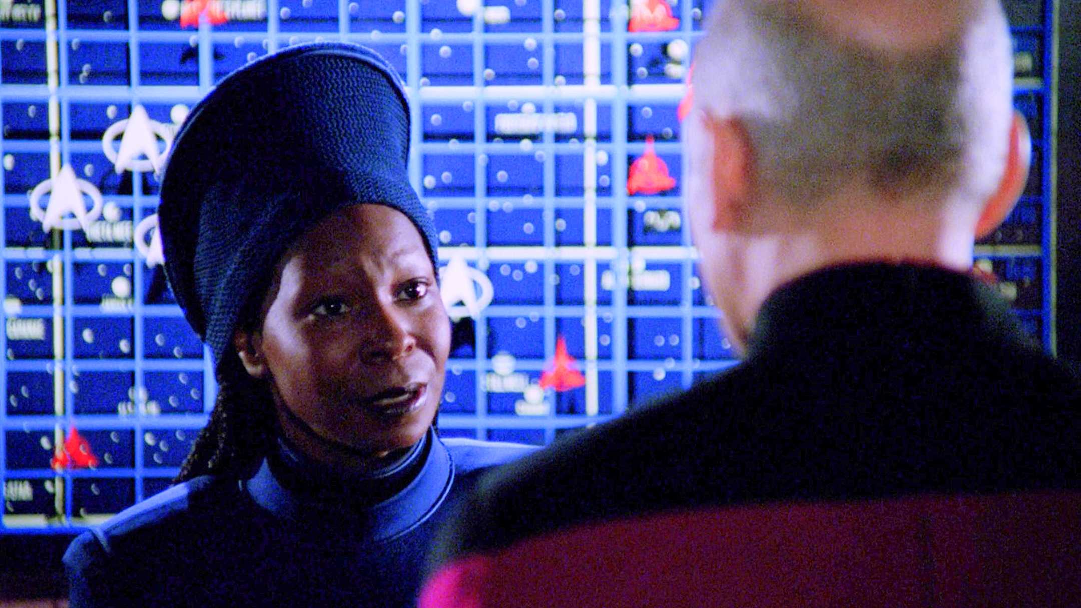 Guinan fala com Picard em frente a um mapa de ficção científica de Star Trek the Next Generation