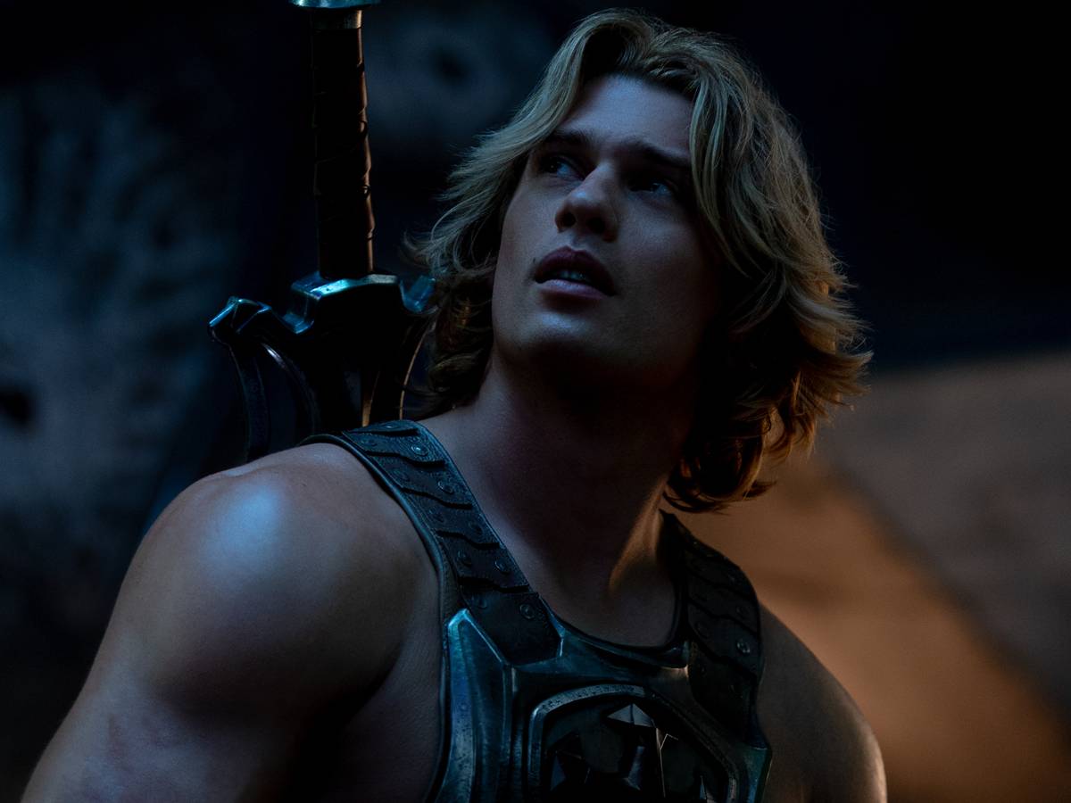 Nicholas Galitzine como He-Man em cena de batalha com espada erguida, visual épico de fantasia live-action