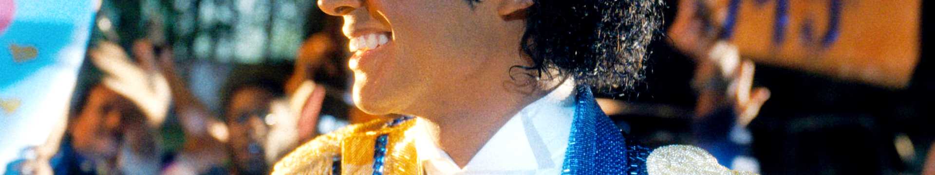Jaafar Jackson como Michael Jackson sorrindo para uma multidão de fãs em Michael 2026