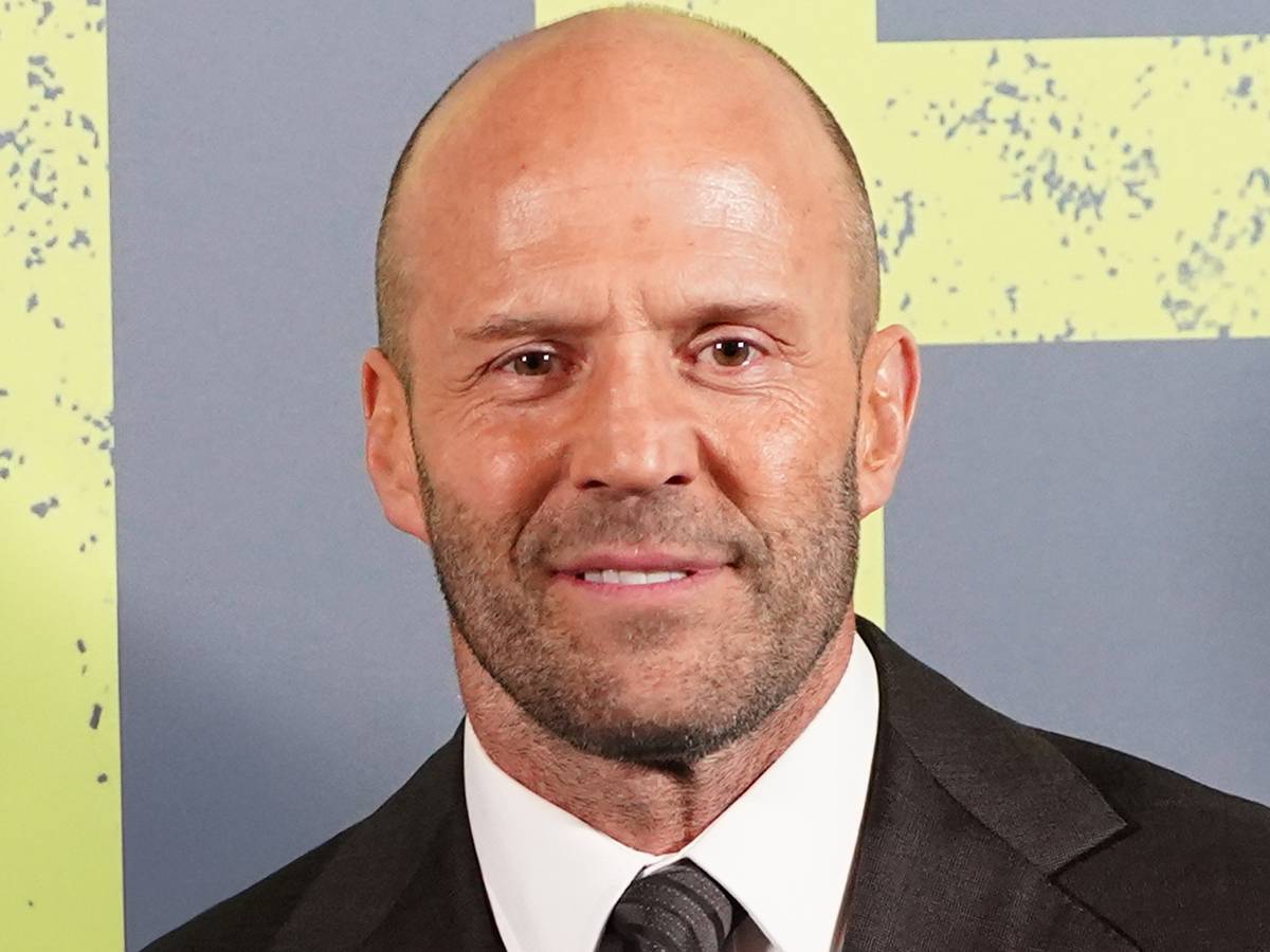 David Leitch dirigindo Jason Statham nos bastidores de um set de ação, equipe técnica ao fundo
