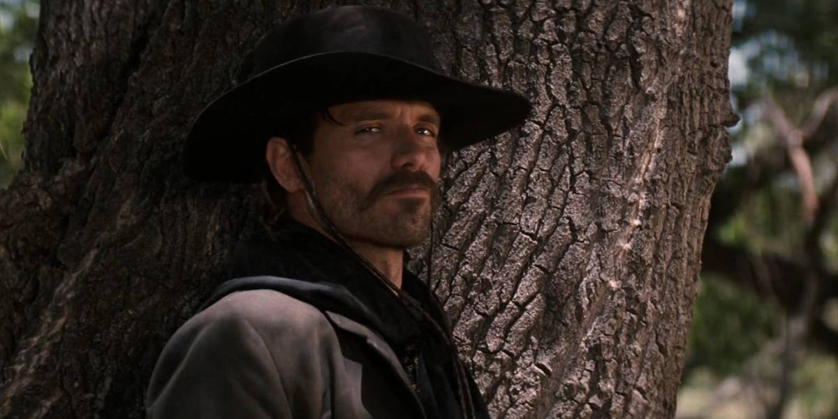 Johnny Ringo (Michael Biehn) encostado em uma árvore