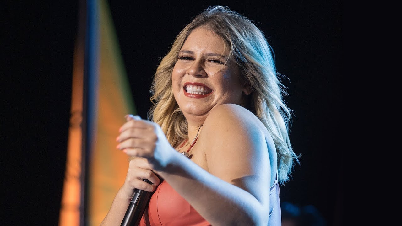 Logo do Prime Video ao lado de foto de Marília Mendonça em apresentação, montagem editorial sobre a série Marília
