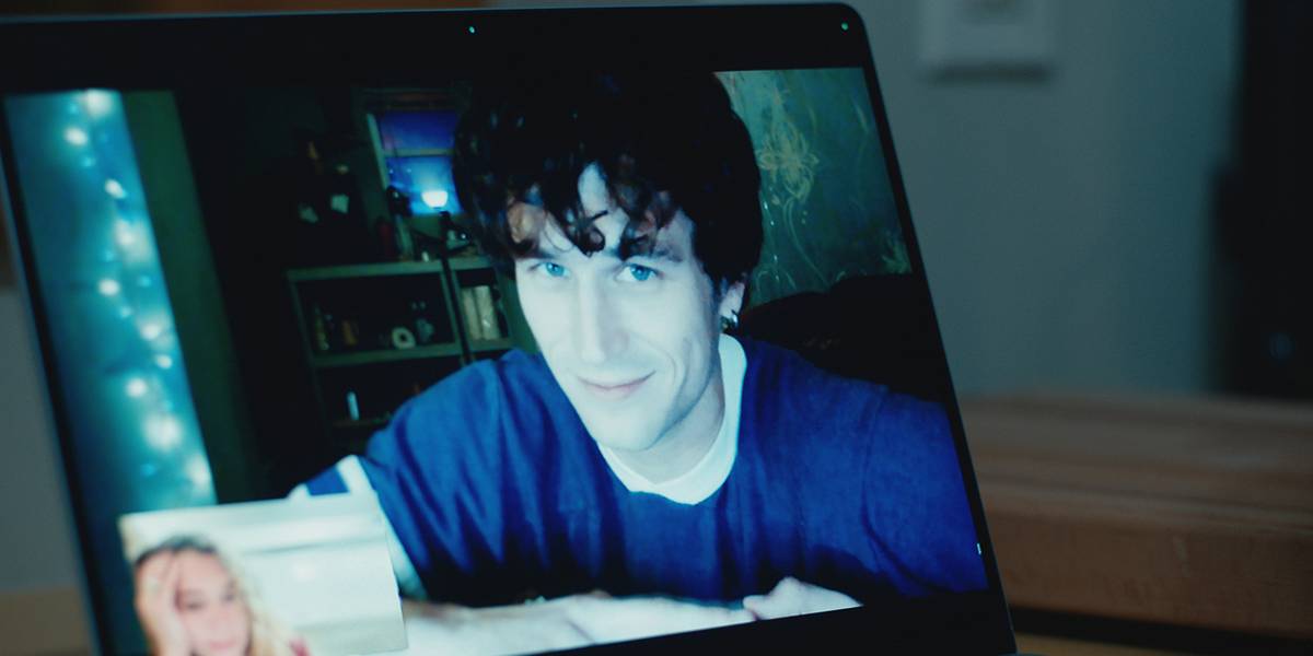 Trevor sorrindo no computador enquanto conversa com Paula em Maximum Pleasure Guaranteed.