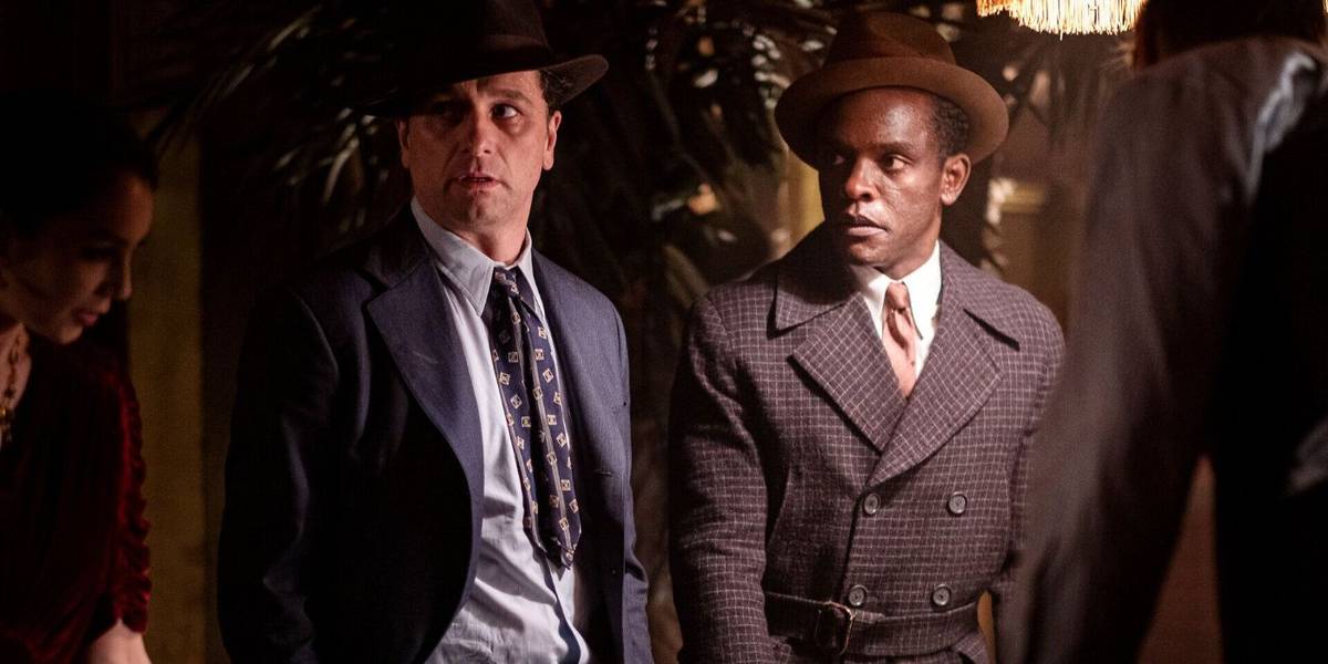 Perry Mason (Matthew Rhys) e Paul Drake (Chris Chalk) olham de lado com interesse em Perry Mason (2020).