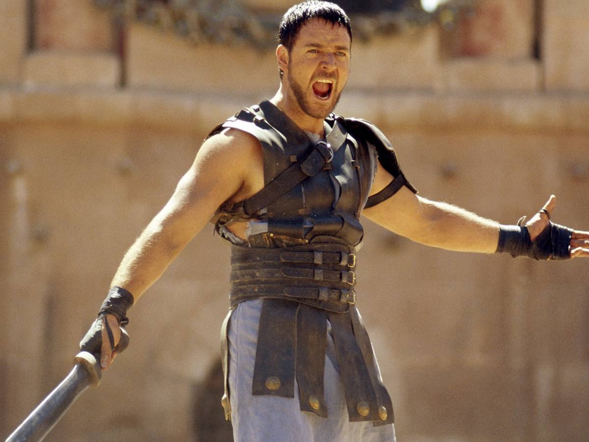 Poster oficial de Gladiador com Maximus no Coliseu e atmosfera épica dourada