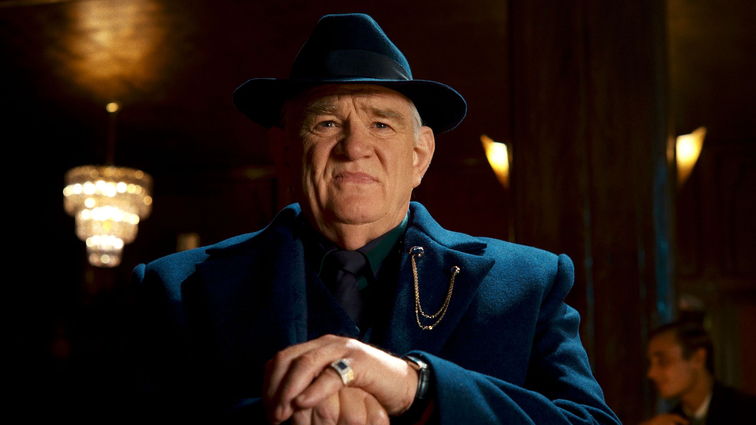Brendan Gleeson como vilão misterioso em cenário noir