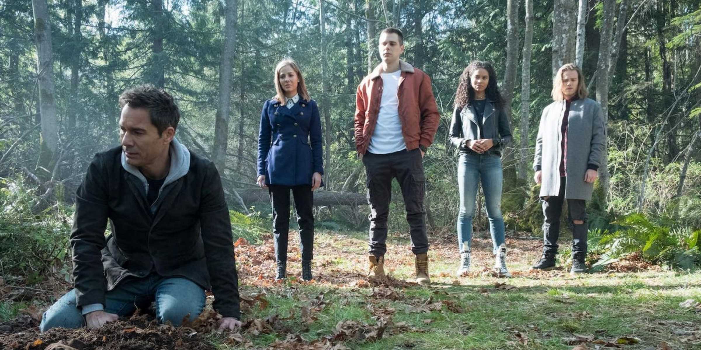 Os personagens principais investigando na floresta em Travelers temporada 3