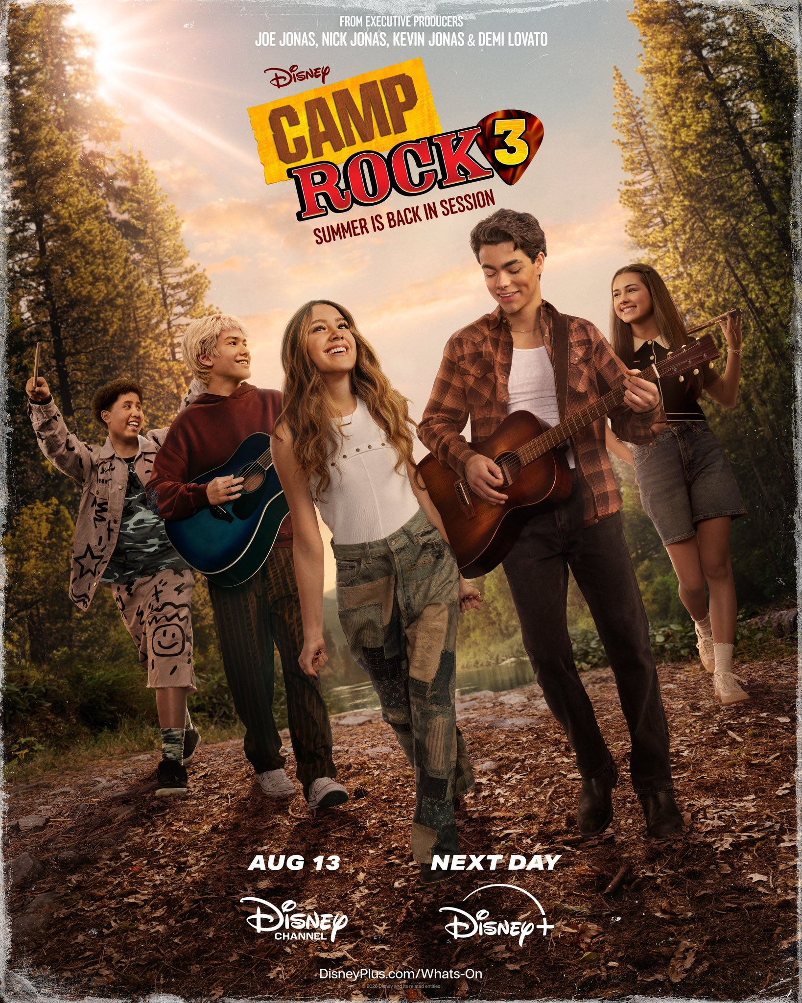 Cena de apresentação musical de Camp Rock 3 com luzes de palco e coreografia em grupo