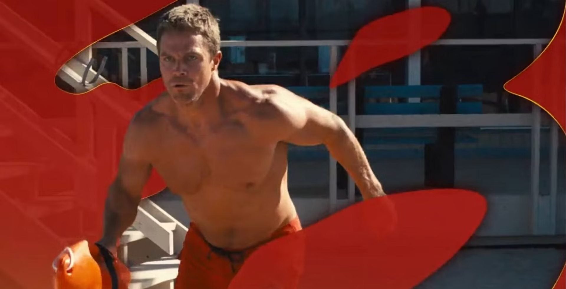 Frame do teaser de Baywatch com resgate no mar e equipe correndo pela praia em câmera lenta