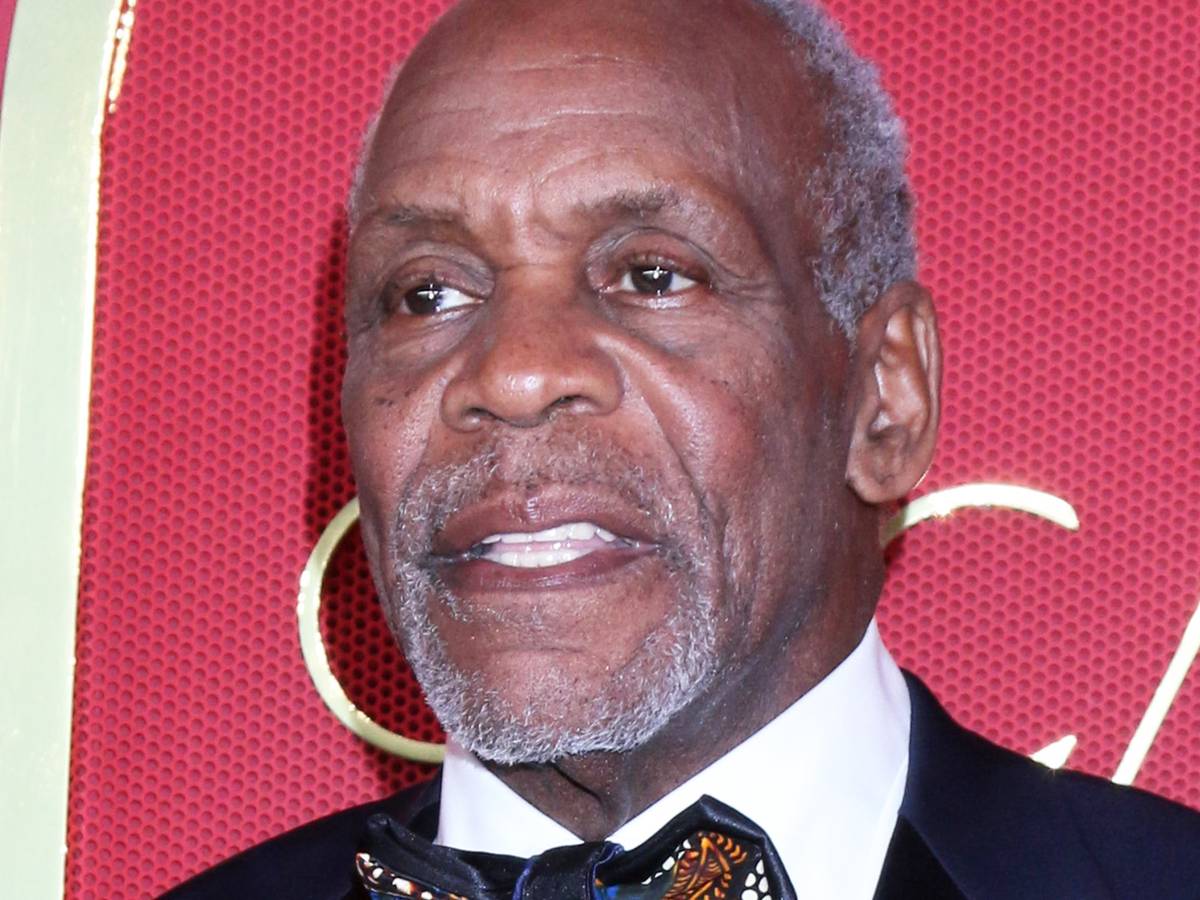 Retrato recente de Danny Glover em evento público, expressão séria e iluminação de tapete vermelho