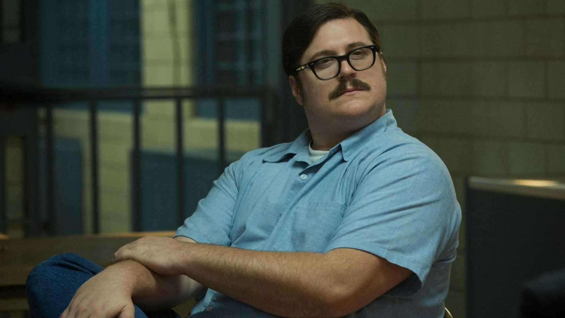 Ed Kemper sorrindo de lado em Mindhunter