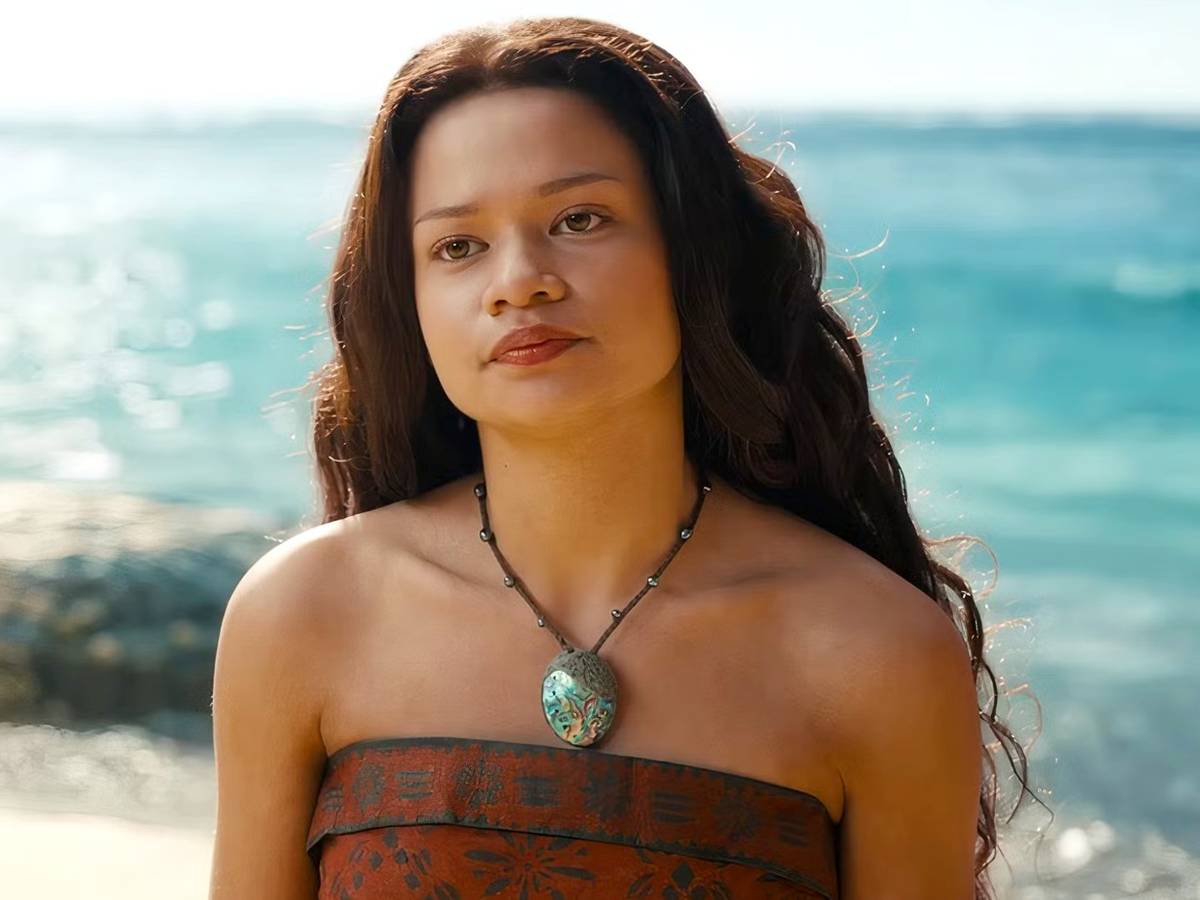 Cena de divulgação do live-action de Moana com Catherine Laga’aia como Moana e Dwayne Johnson como Maui em uma praia tropical