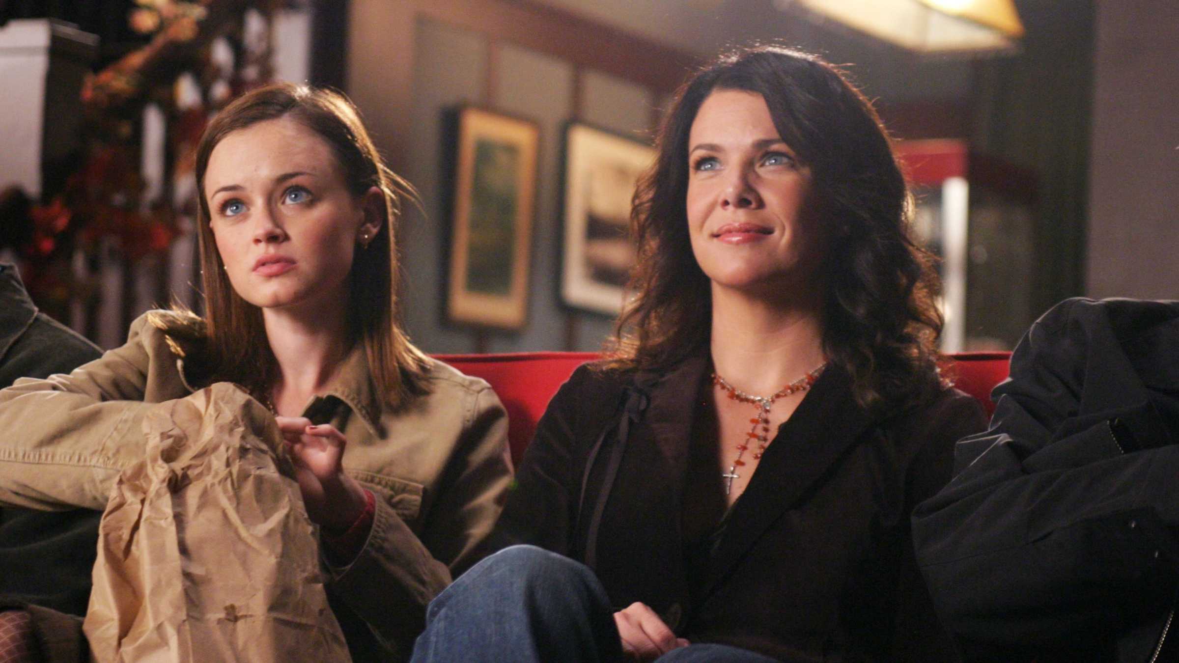 Rory (Alexis Bledel) e Lorelai (Lauren Graham) sentadas juntas em um sofá em Gilmore Girls