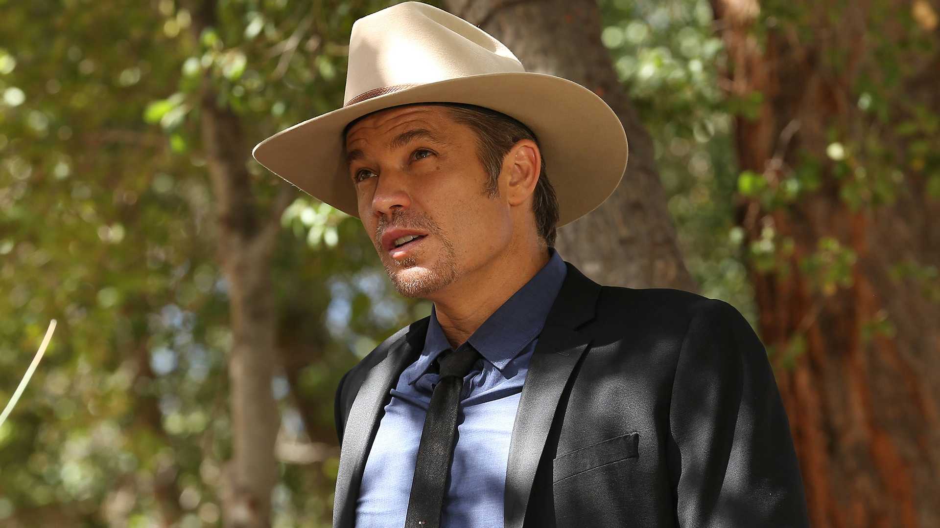 Timothy Olyphant caminha pela floresta em Justified.